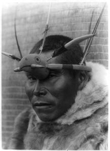 A Nunivak Cup'ig man with raven maskette. The raven (Cup'ig tulukarug) is Ellam Cua or Creator god in the Cup’ig mythology